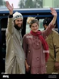 Swiss couple David Och and Daniela Widmer wave upon their arrival at Qasim  military base in Rawalpindi, Pakistan