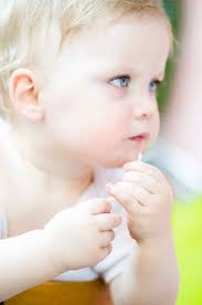 Baby girl eating spaghetti, close up stock photo