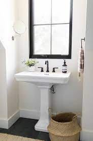 The sophisticated glossy white pedestal sink has a stylish acrylic finish and single fau. White Pedestal Sink With A Swing Arm Shaving Mirror Under A Black Bathroom Window Featuring Black Faucet Bathroom Small Bathroom Mirrors Small Bathroom Window