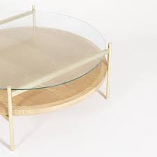 Get this awesome wood and brass coffee table here! Duotone Coffee Table Round Brass Clear Glass Ash Wood Rouse Home
