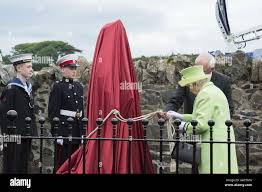 Queen Elizabeth II prepares to unveil a statue of Robert Quigg, VC during a  visit to Bushmills Village