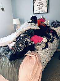 all clothes placed in a pile on the bed clothes laundry clothes bed