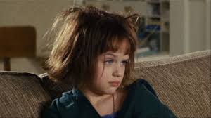 All we see is a shadowy corner behind a bedroom door. Joey King El Conjuro