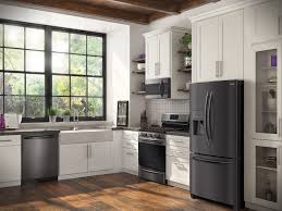 The black stainless steel refrigerator creates cool contrast against the rustic wood wall and floor, while the sleek stove range hood pops against the bright white subway tile backdrop. Frigidaire Gallery Black Stainless Steel Abc Warehouse