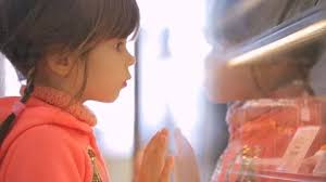 Little girl choosing cake at grocery store