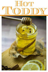 A Warm And Comforting Hot Toddy In A Mason Jar With A Lemon Wedge Cloves And Honey Drizzling Into The Glass Hot Toddies Recipe Hot Toddy Toddy Recipe