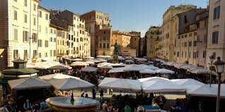 Campo de' fiori is a rectangular square south of piazza navona in rome, italy, at the border between rione parione and rione regola. Piazza Campo De Fiori Rome Zonzofox
