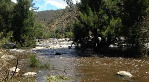 A child is playing in a puddle of water while wearing only a loin cloth. Kambah Pool Swimming Sunbathing And Sex The Riotact