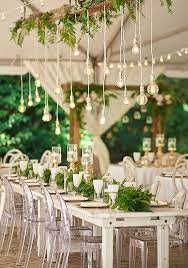 An Overhead Wedding Decoration With Cascading Ferns And Some Bulbs Hanging Down Classic White Wedding Table Lighting Wedding Table Fern Wedding