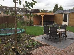 gezind tuin met terras in de zon veranda trampoline en gazon op te spelen of te luieren foto genomen vrijwel direct na de aanleg herfst 20 tuin terras gazon