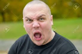 Joven Tirando De Una Cara Fea Amenazante A La Cámara Boquiabierto Y  Frunciendo El Ceño Con Una Mirada Siniestra Al Aire Libre En Un Parque  Fotos, retratos, imágenes y fotografía de archivo