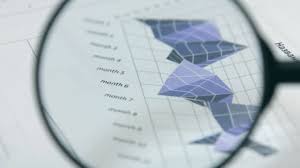 rotation studying charts with a magnifying glass financial analysis