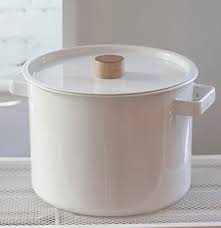 Red enamel pan with handle on blue background, top view. White Enamel Cookware Design Sponge