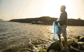 Asian fishermen throwing fishing net during twilight on wooden boat at the lake. Man Throwing Fishing Net Into Ocean