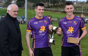 County Secretary Seán Óg McAteer presents the Patrick Dinsmore Cup to  Carryduff joint captains James Guinness and Josh Connery