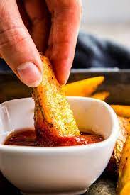 Dipping Baked Potato Wedges In Ketchup Potato Wedges Baked Baked Potato Wedges Recipe Recipes