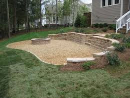 Furniture placement around corner fireplace next to outdoor privacy screen alongside deck and balcony railing. Pea Gravel Backyard Fire Outdoor Fire Fire Pit Patio