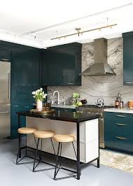 White and blue kitchen with a peacock blue cabinet design topped with brass pulls and gray marble countertops. Glossy Blue Kitchen Cabinetry With Gray Marble Contemporary Kitchen