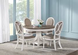 Choose a dining table and chairs with simple, streamlined shapes that won't take up too much space, and hang a light fixture above to define the table area. French Market White 5 Pc Round Dining Room Traditional