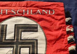 The flag background is red silk with white ribbed silk circle in the middle with a black silk swastika with silver bullion ribbon out line. Deutschland Erwache Standard Flag