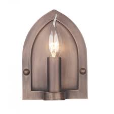 The sonneman candle wall sconce is an homage to the ancient lighting practice, the form is made modern with a sleek shape and contrasting materials. Copper Medieval Candle Style Wall Light With Gothic Arch Back