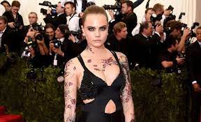 It features a snake that starts at her palm and slithers down her middle finger, and the word feral. A Complete Guide To Cara Delevingne S Tattoos And Their Meanings Grazia