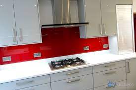 A grey gloss kitchen with contrasting quartz glass effect splashback. High Gloss Grey Gloss Real Kitchens