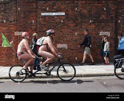 Two semi naked Cyclists on a tandem pass a family as a young girl covers  her eyes during the Portsmouth World Naked bike ride 2014 Stock Photo -  Alamy