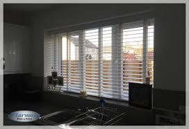 measure taped wooden blinds in a kitchen