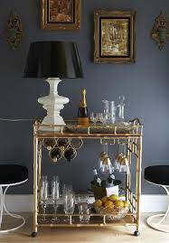 Interior Design Brass Gold Bar Cart With White Table Lamp Veuve Champagne Gold Dipped Wine Glasses Sparkling Water In Home Bar Sets Bar Furniture Home Decor