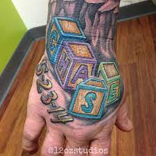 Awesome Full Color Male Hand Tattoo Of A Customer S Kid S Name And Birth Date In Building Letter Blocks By Hand Tattoos For Guys Hand Tattoos Tattoos For Kids