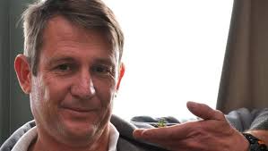 A man, a praying mantis, and the lens of a camera