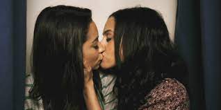 Happy young handsome father sitting on sofa, holding on lap small children daughters, enjoying tender sweet moment at home. 10 Girls Get Real About Their First Kisses With Girls