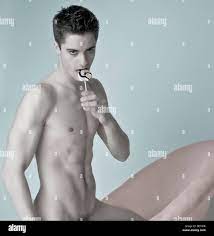 Young muscular man, lollipop, free torso, kneeling on chair, nude Stock  Photo - Alamy