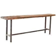 An antique italian console or library table offers walnut construction with top having carved stylized foliate trimming over triple drawer case, raised on trestle base with shaped ly. Vintage Industrial Console Table With Iron Base And Rustic Slab Wood Top At 1stdibs