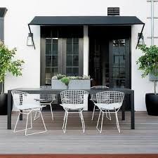 Long Black Outdoor Dining Table With White Bertoia Chairs Outdoor Tables And Chairs White Outdoor Table Outdoor Furniture Ideas Backyards