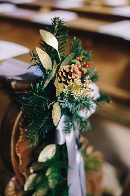 Winter wedding pew decoration idea with pine cones, fir twigs and golden eucalyptus