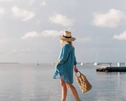 Image of woman wearing a swimsuit, coverup, and flipflops at a Texas beach