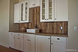 White shaker cabinets black countertops and white stone slab backsplash. Selecting The Right Cabinet Hardware Cabinets Com