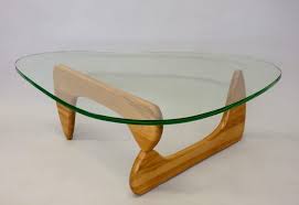 In that spirit, he crafted two pieces of solid wood, curved and interlocking to create a tripod topped by a gently curving, biomorphic shaped piece of glass. Early 1950s Isamu Noguchi Birch Base Glass Top Coffee Table At 1stdibs