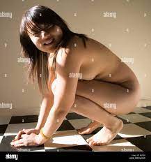 Young nude Asian woman crouching on black and white checker tiled floor  smiling Stock Photo - Alamy