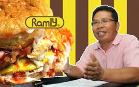In a small area next to it, tables and chairs are arranged for dining or waiting. Kisah Pengasas Dan Pemilik Syarikat Ramly Burger Iluminasi