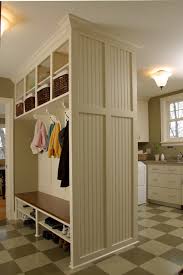 Sunken laundry room and mudroom combo feature gray cabinets with brass pull and a vintage wall mount sink faucet beside a subway tiled dog tub. 6 Laundry Room Remodeling Trends