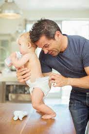 Father Checking Baby's Diaper Stock Photo