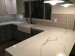 The white shaker cm341 is: Calacatta Classique Quartz Slab Quartz Countertops Countertops Kitchen Countertops