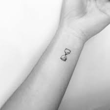 1001 Ideen Und Bilder Zum Thema Sanduhr Tattoo Eine Hand Mit Einem Tattoo Kleine Schwarze T Towierung Am Handgel Hourglass Tattoo Small Black Tattoos Tattoos