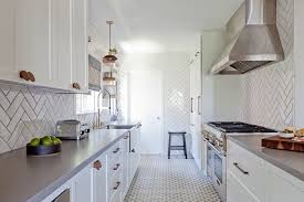 You can use tile of all the same color, change colors in a stripe, create an ombré effect, or mix colors randomly. White Herringbone Tile Kitchen Floor Design Ideas