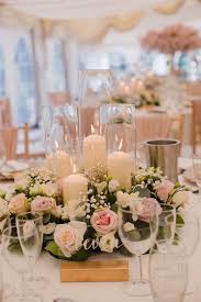 Flower and candle centerpieces for your day and evening wedding reception. Rose And Gypsophila Wedding Table Centre Piece With Hurricane Candles Flower Centerpieces Wedding Candle Wedding Centerpieces Wedding Floral Centerpieces
