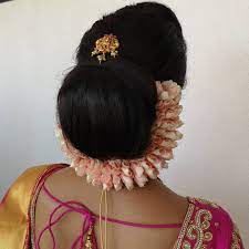 A Simple Chignon Bun With A Baby Pink Rose Petal Kondai Malai Chignon Bun Chignon Bun Hairstyles