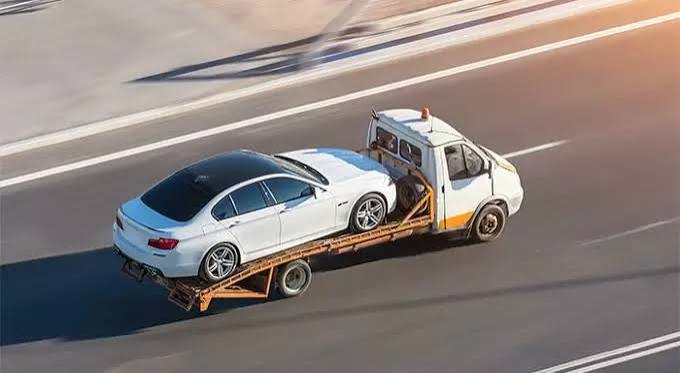 Flatbed tow truck towing a vehicle